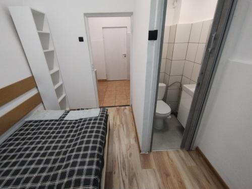 um pequeno quarto com uma cama e um WC em VasylOk em Varsóvia