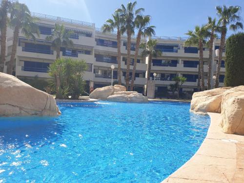 プレヤス・デ・オリフエラにあるLa Calma - one bedroom apartment by the pool in Playa Flamencaの建物の前の青い水のスイミングプール