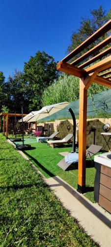 a park with tables and umbrellas on the grass at Le rose di Mapi in Mango