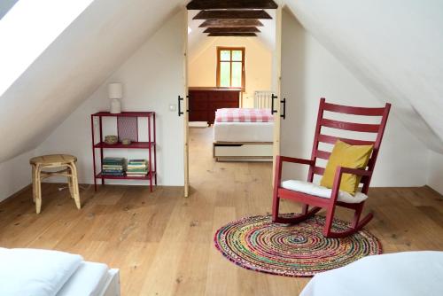 een zolderkamer met een stoel en een bed bij Kellerstöckl - Am Vierkanthof 