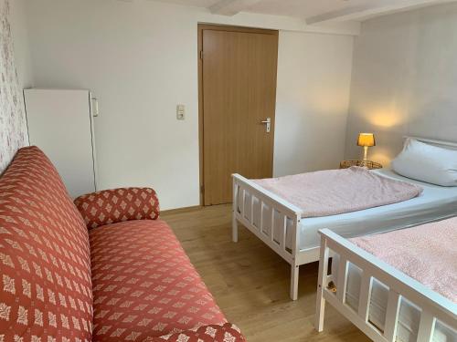 a room with two beds and a couch in it at Monteurswohnung am Ederseeradweg mit 2 Schlafzimmern, Terrasse, Parkplatz - einfach in Waldeck