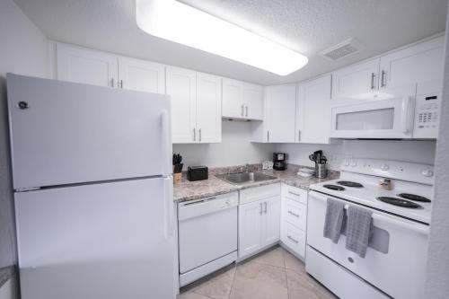 een keuken met witte apparatuur en een witte koelkast bij 214 Fully Furnished 1BR Suite-Outdoor Pool in Scottsdale