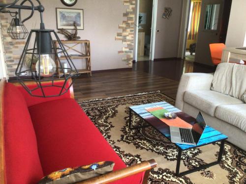 a living room with a red couch and a table at Cosy Appartment. Püssi town in Pyussi