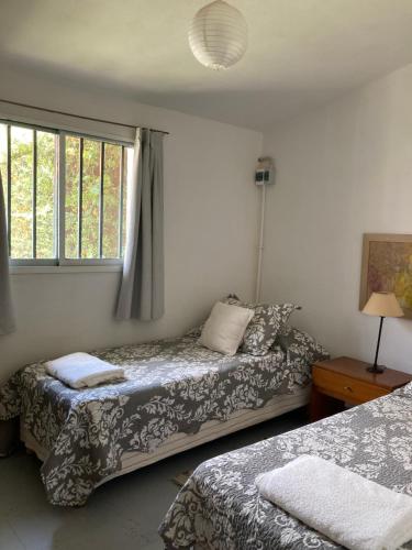 a bedroom with two beds and a window at La Casita in La Cumbre