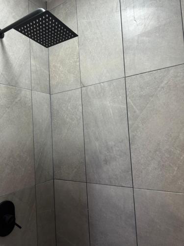 a shower in a bathroom with a tile floor at Casa Nórdica - Monterrey in Monterrey