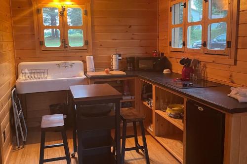 a kitchen with a sink and a tub in a cabin at Rustic Lakefront Cottage Derby Paddles Lodge in Derby Center