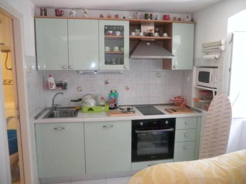 a small kitchen with blue cabinets and a sink at Guest House Periko in Split
