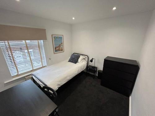 a bedroom with a bed and a window at Modern & Bright 4 Bedroom Home in Stoke on Trent