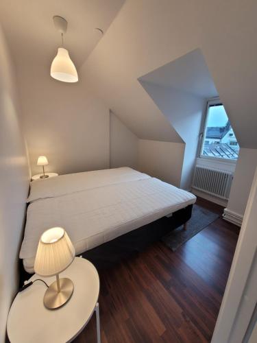 a bedroom with a bed and a table with a lamp at Home Inn SVE102 in Stockholm