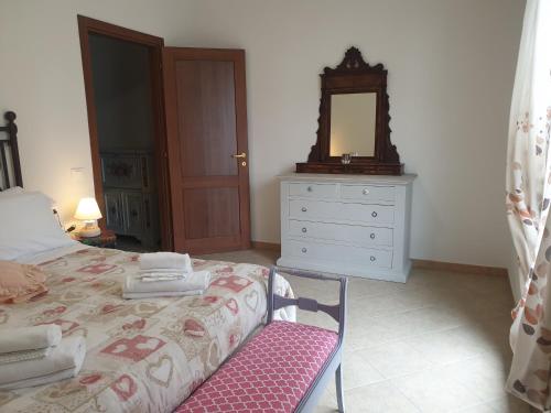 ein Schlafzimmer mit einem Bett mit einem Spiegel und einer Kommode in der Unterkunft Appartamento I Tulipani. Camera I Tulipani Rossi in Barberino di Mugello