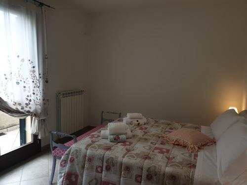 ein Schlafzimmer mit einem Bett mit einer Decke und einem Fenster in der Unterkunft Appartamento I Tulipani. Camera I Tulipani Rossi in Barberino di Mugello