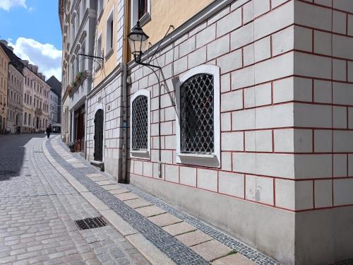 a brick building with two windows on a street at FILMAP- charmante Kreuzgewölbe-Whg im Herzen der Altstadt-Ideal für Paare & Geschäftsreisende in Görlitz
