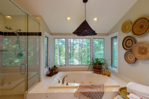 Pisgah ForestにあるThe Treehouseのバスルーム(バスタブ、シャワー、窓付)が備わります。