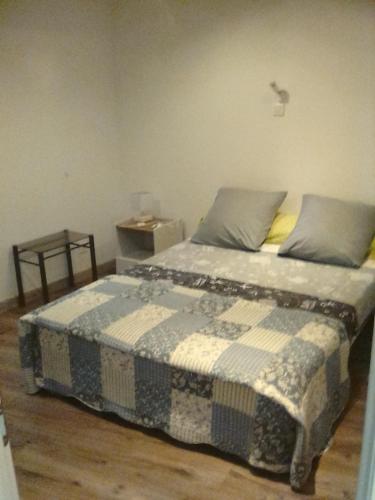 une chambre avec un lit avec une couverture bleue et blanche dans l'établissement 2+1 couchages + sdb dans appartement rénové., à Caunes-Minervois