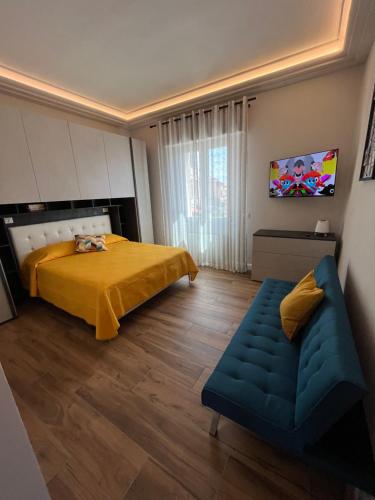 1 dormitorio con cama amarilla y sofá en DiLuna, en Marina di Cecina