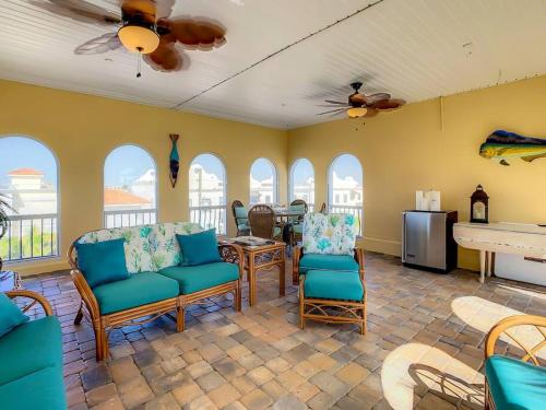 a living room with chairs and a table and windows at Clearwater Penthouse 5 min Beach walk Heated Pool in Clearwater Beach