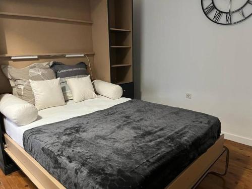 une chambre avec un grand lit avec une horloge au mur dans l'établissement suite totem, à Lyon