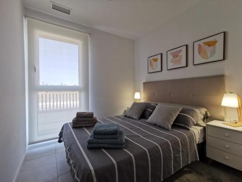 ein Schlafzimmer mit einem großen Bett mit zwei Handtüchern darauf in der Unterkunft Turquesa Del Mar - Max Beach Golf - Ground Floor Apartment in Playa Flamenca