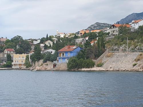 a group of houses on a hill next to the water at Apartman Nina in Karlobag