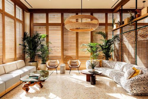 a living room with a couch and some plants at Hotel June West LA, a Member of Design Hotels in Los Angeles