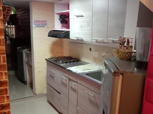 a kitchen with a stove and a sink in it at APARTAMENTO PARA TRES PERSONAS a 10 minutos del centro de eventos valle del pacifico y a la misma distancia del centro de la ciudad Y también a 300 mts del Orquideorama in Cali