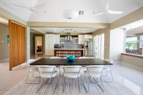 a dining room with a table and white chairs at Crystal Blue Water Front Home with Pool in Providenciales