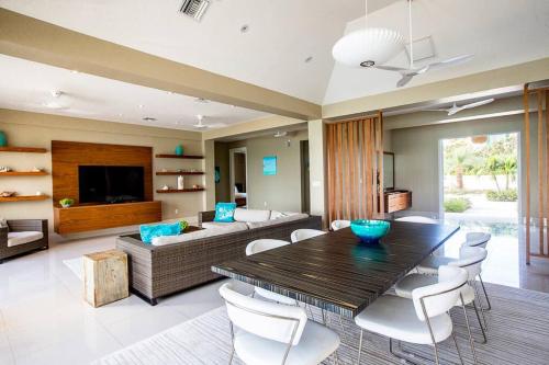 a living room with a table and a couch at Crystal Blue Water Front Home with Pool in Providenciales