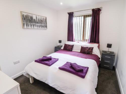 a bedroom with a bed with purple towels on it at Sunset Lodge - No 6 in Lincoln