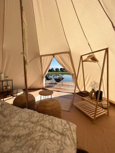 a bedroom with a tent with chairs and a table at Glamping Rusne in Rusnė