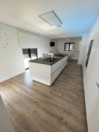 a kitchen with white cabinets and a counter top at Casa do Titó in Lanhelas
