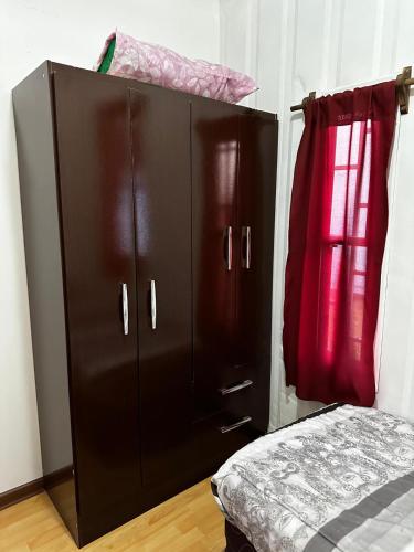 Armario negro con cama en una habitación en La Posada del Viajero, en Durazno