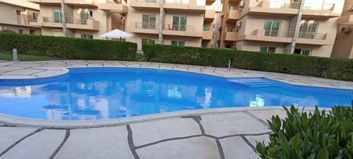 a large blue swimming pool in front of a building at مارينا دلتا ولاجونز in Al Ḩammād