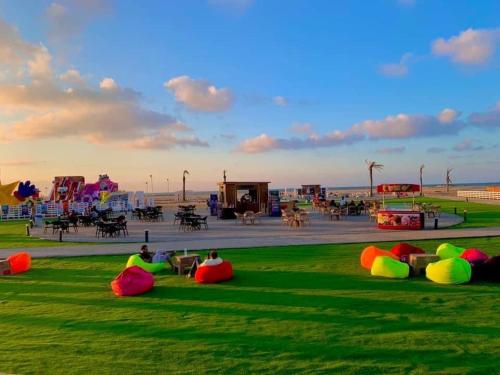 un grupo de personas sentadas en la hierba en un parque en حجز شاليهات مارينا دلتا ومارينا لاجونز en Al Ḩammād