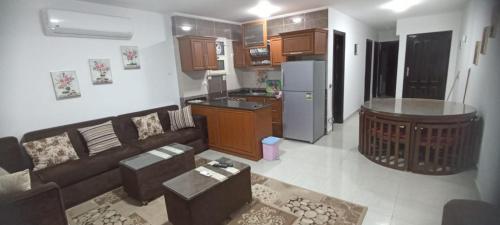 a living room with a couch and a kitchen at مارينا دلتا ولاجونز in Al Ḩammād