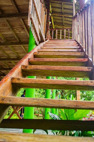 a wooden stairway with green columns in a building at Hostal Flor Tayrona in Santa Marta