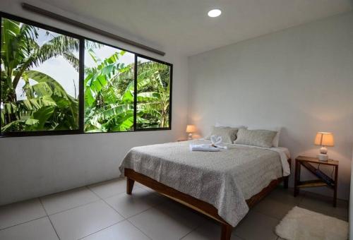 a bedroom with a bed and a large window at Casa Curré Monteverde in Monteverde Costa Rica