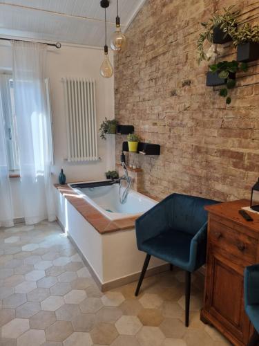 uma casa de banho com uma banheira e uma cadeira azul em OgniVolta em Pienza