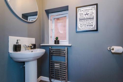 uma casa de banho com um lavatório e um espelho em Luxury Large Leeds 10bed 2.5bath Modern House Free Parking em Robin Hood