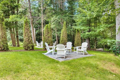 a group of white chairs and tables in the grass at The Inn & More in Bartlett
