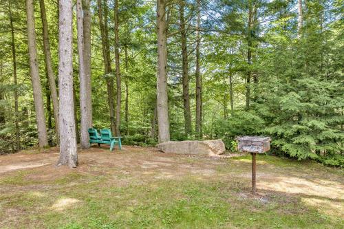 a blue bench sitting in the woods with a sign at The Inn & More in Bartlett