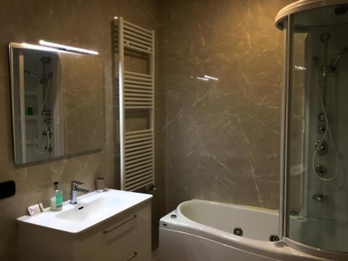 a bathroom with a sink and a shower and a tub at Erania Apartments in Sala Consilina
