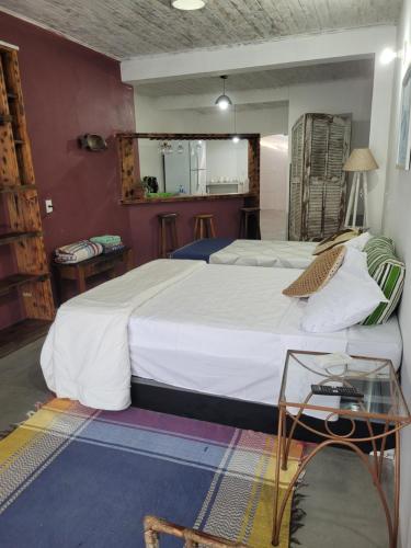 a bedroom with a large bed with a glass table at Loft Térreo no Centro in Búzios
