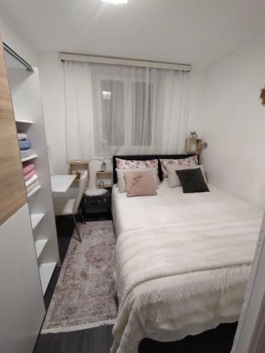 um quarto com uma grande cama branca e uma janela em Alba Crikvenica em Crikvenica