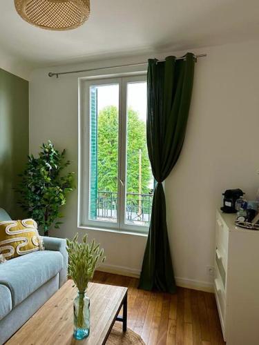 uma sala de estar com um sofá e uma janela em Joli Studio proche Paris; Stade de France em Saint-Denis