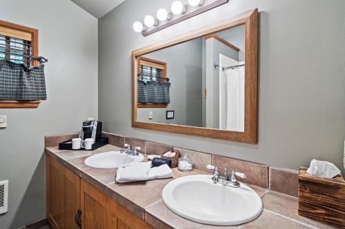 a bathroom with two sinks and a large mirror at Weasku Inn in Grants Pass