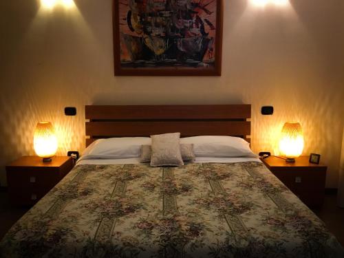 a bedroom with a large bed with two lamps at Erania Apartments in Sala Consilina