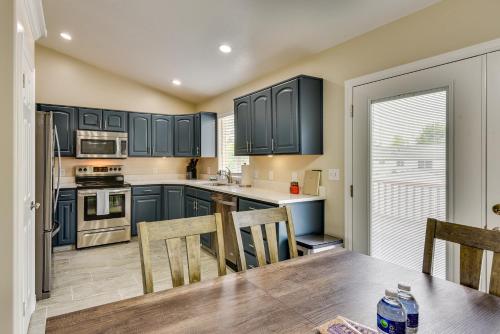 a kitchen with blue cabinets and a table with chairs at Family-Friendly Clearfield Home with Hot Tub! in Clearfield