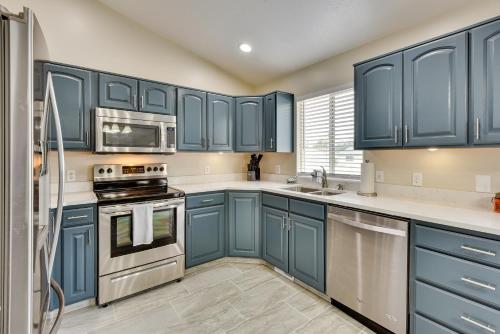 a blue kitchen with stainless steel appliances and blue cabinets at Family-Friendly Clearfield Home with Hot Tub! in Clearfield
