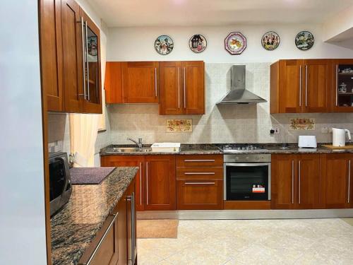 a kitchen with wooden cabinets and a stove top oven at Timeless Elegance: Vintage 3-Bedroom Apartment 