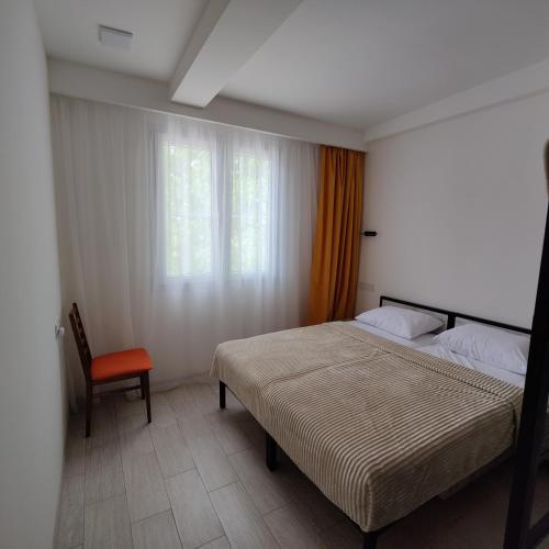 ein Schlafzimmer mit einem Bett und einem Stuhl und einem Fenster in der Unterkunft Checkpoint Goght in Goghtʼ